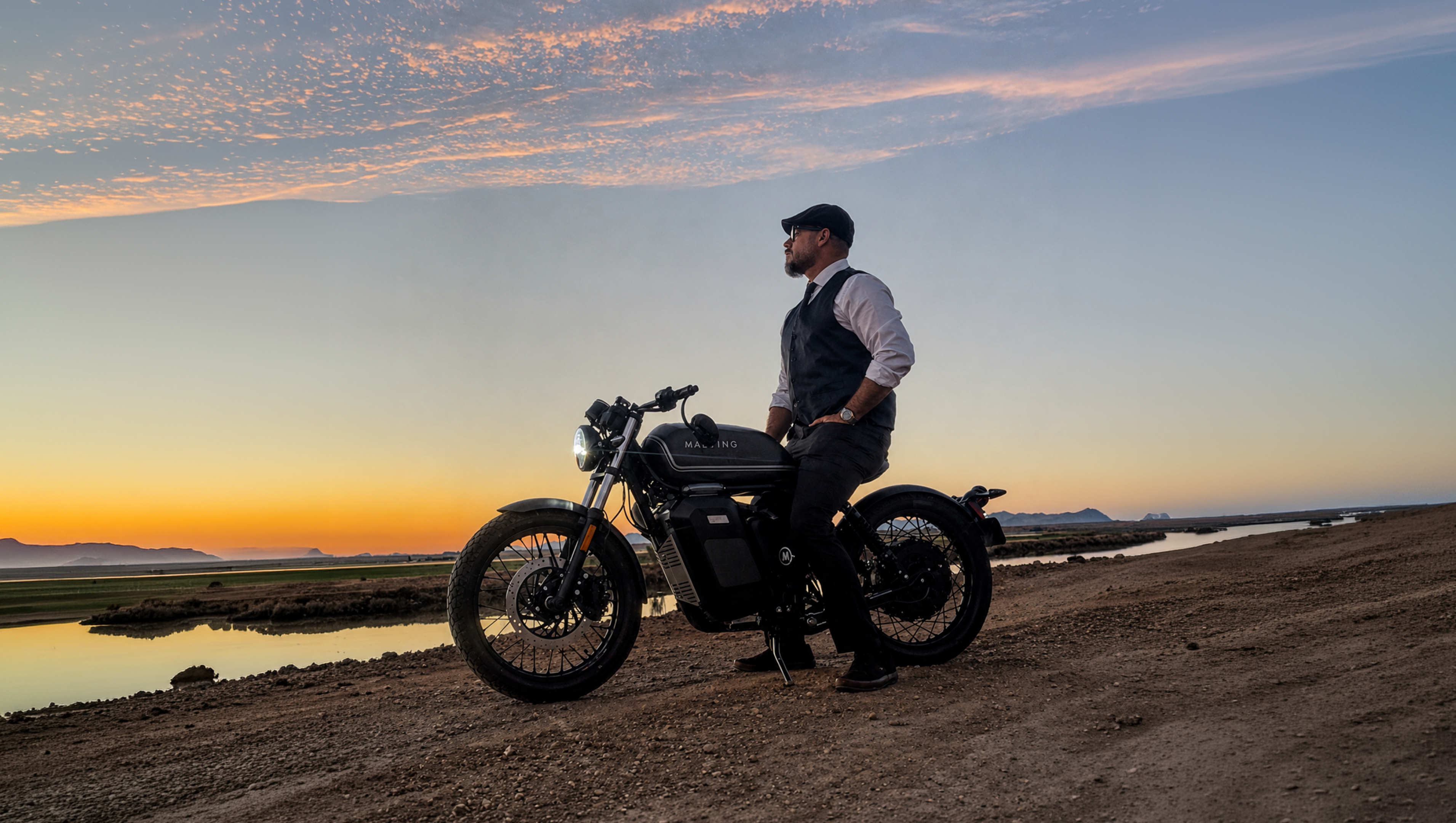 Maeving electric motorcycle rider on hill top with view