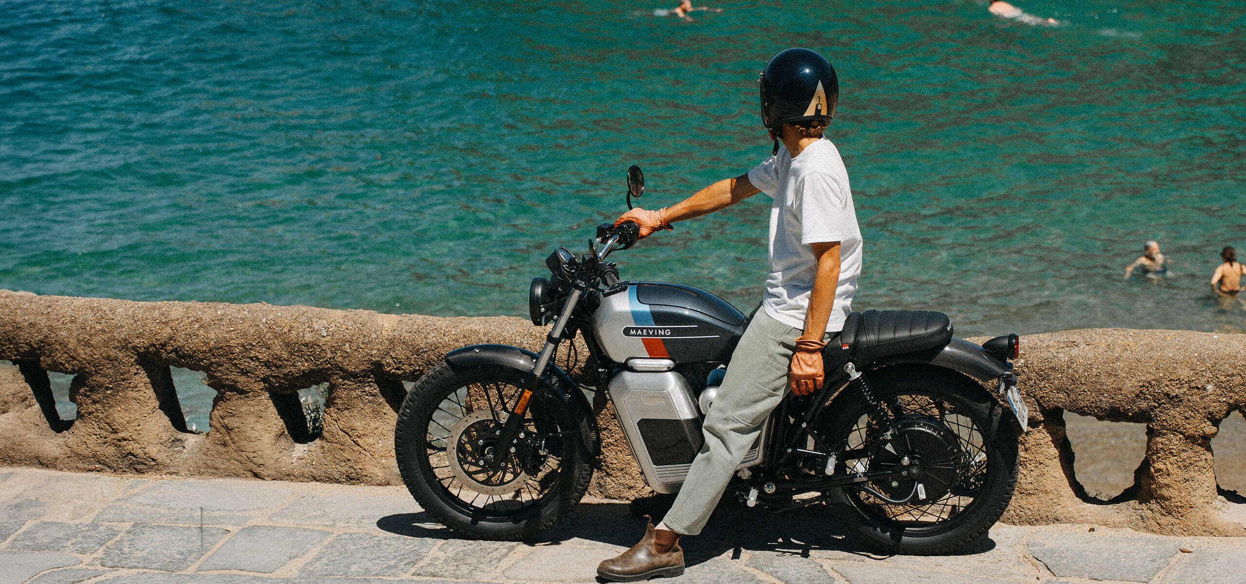 Maeving RM2 Electric Motorcycle rider sitting on the bike by the sea